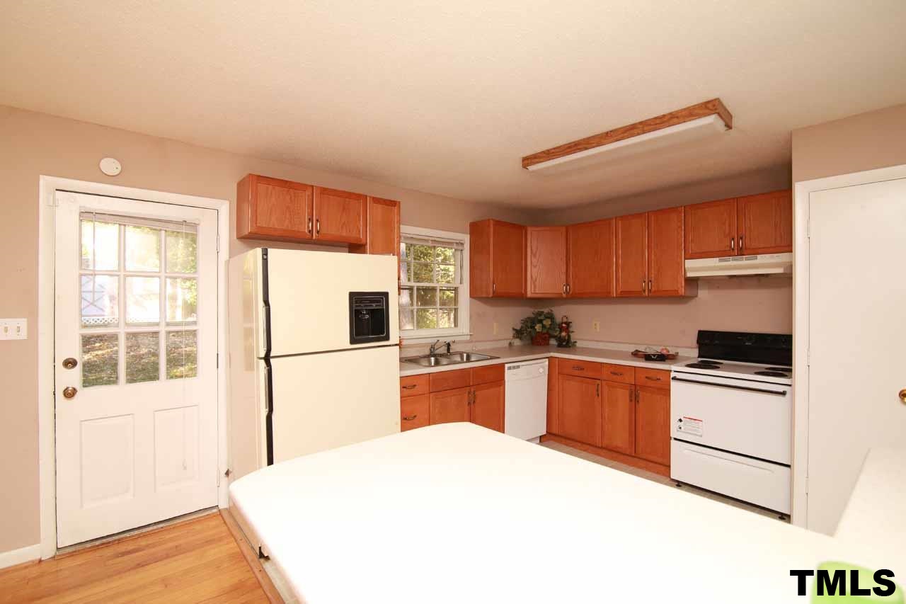 411 East Rowan Street Raleigh, NC 27609 - Photo 11 of 25 a kitchen with granite countertop a refrigerator stove top oven and sink