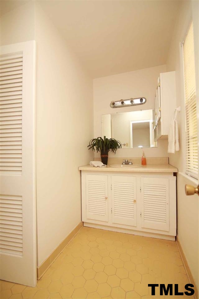 411 East Rowan Street Raleigh, NC 27609 - Photo 17 of 25 a bathroom with a sink a mirror and shower