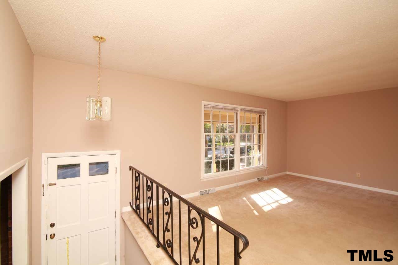 411 East Rowan Street Raleigh, NC 27609 - Photo 5 of 25 a view of an empty room with wooden floor and a window