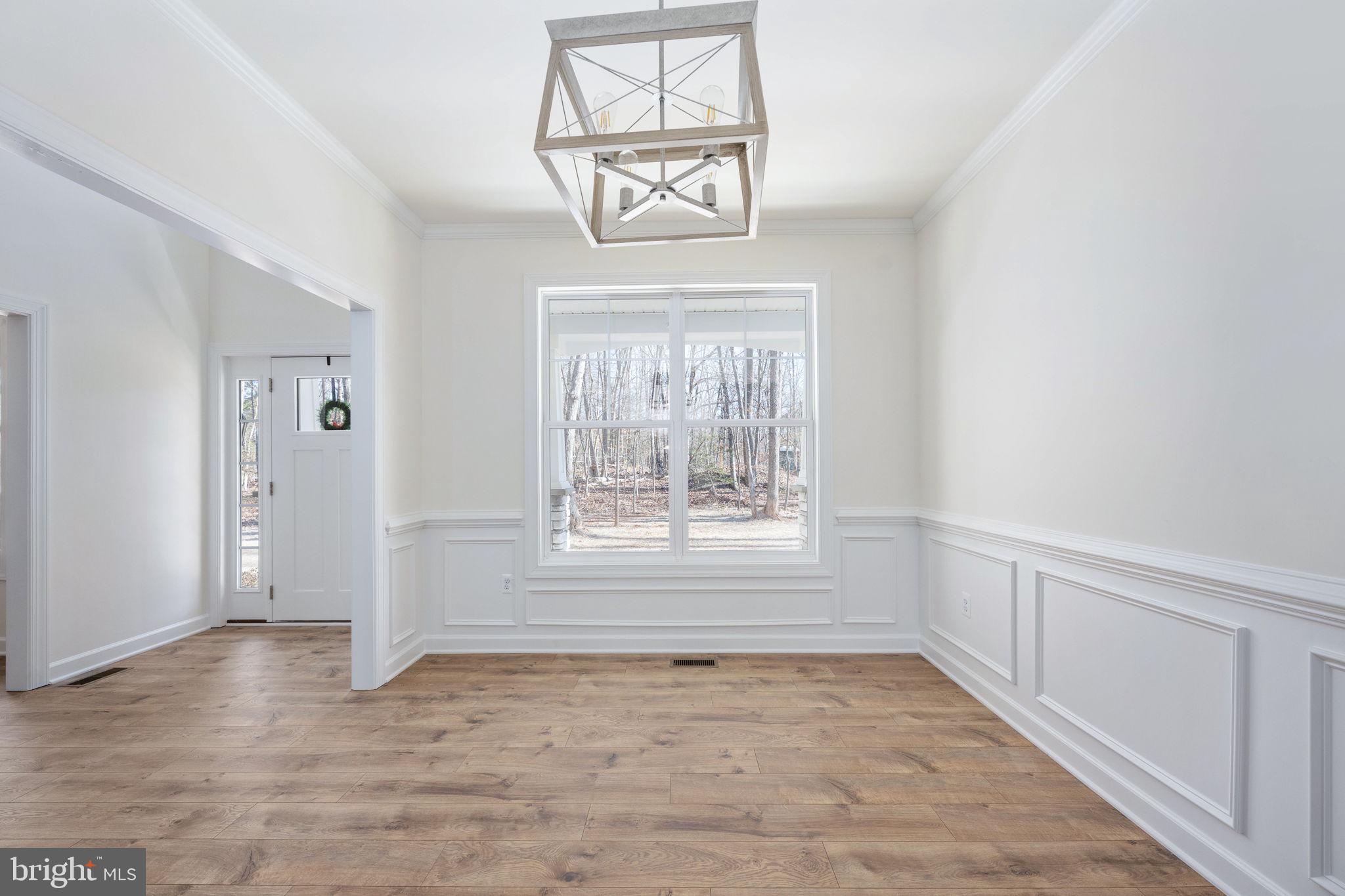 569 Tacketts Mill Road Stafford, VA 22556 - Photo 36 of 120 an empty room with wooden floor a chandelier and windows