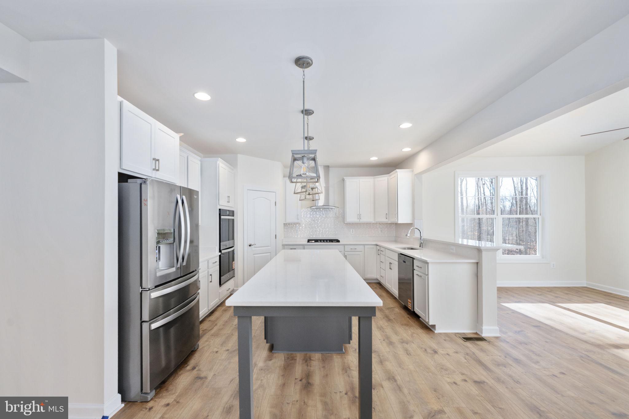 569 Tacketts Mill Road Stafford, VA 22556 - Photo 50 of 120 a kitchen with stainless steel appliances granite countertop a refrigerator oven a sink dishwasher and white cabinets with wooden floor