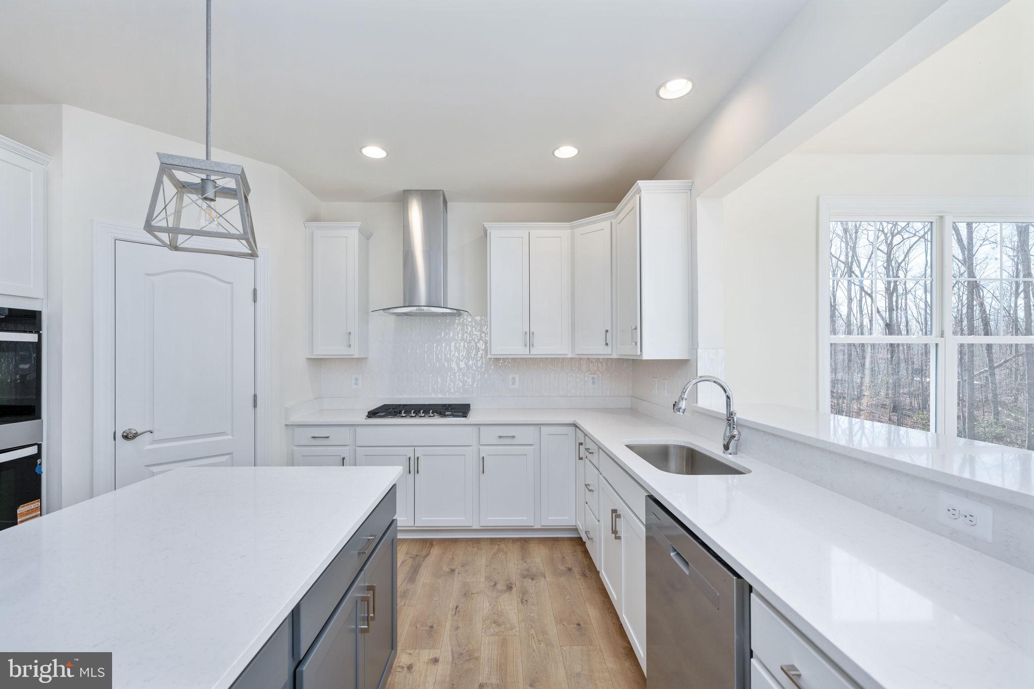 569 Tacketts Mill Road Stafford, VA 22556 - Photo 53 of 120 a kitchen with a sink a stove a refrigerator and white cabinets
