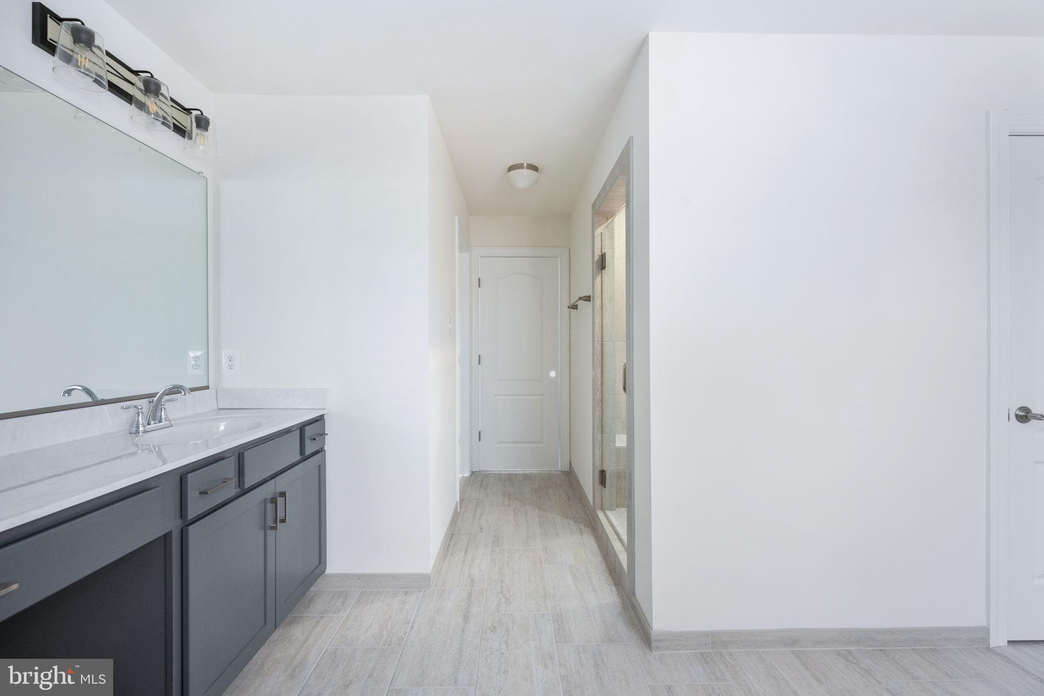 569 Tacketts Mill Road Stafford, VA 22556 - Photo 97 of 120 a bathroom with a granite countertop sink a mirror and a vanity
