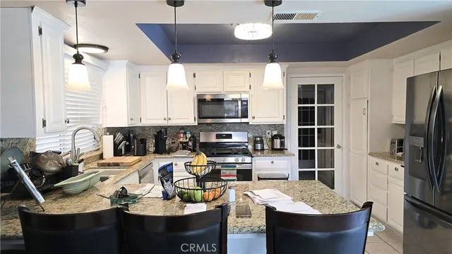 a kitchen with a appliances a dining table and chairs