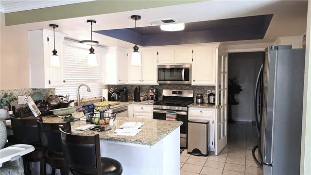 a kitchen with a sink stainless steel appliances and white cabinets