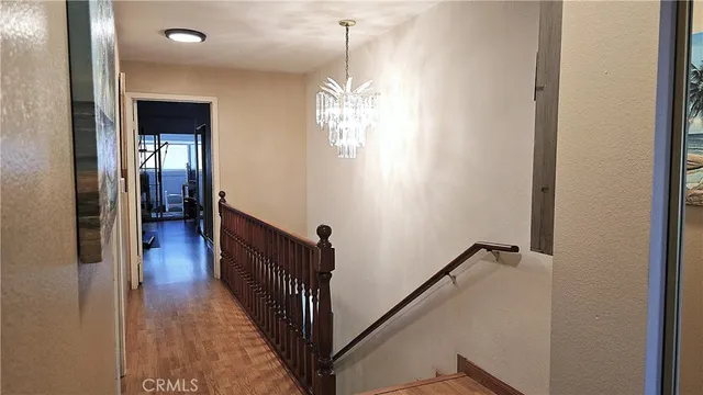 a view of a hallway with wooden floor and staircase