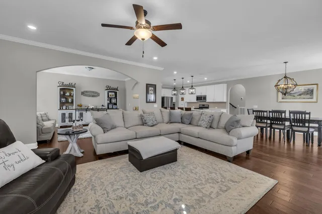 a living room with furniture wooden floor and a chandelier