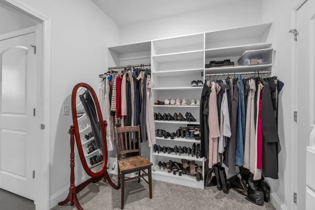 a view of walk in closet with clothes and shoes
