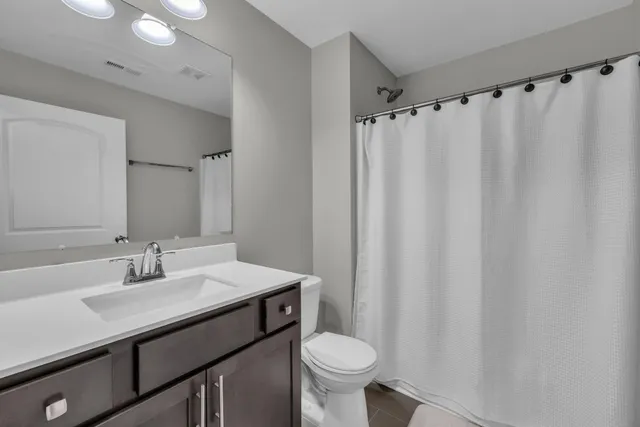 a bathroom with a sink a toilet and shower curtain