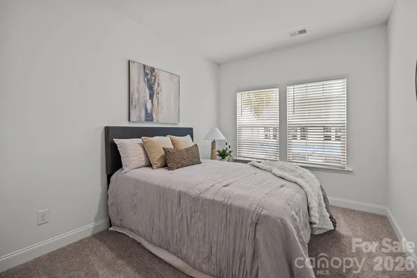 a large bed sitting in a bedroom next to a window