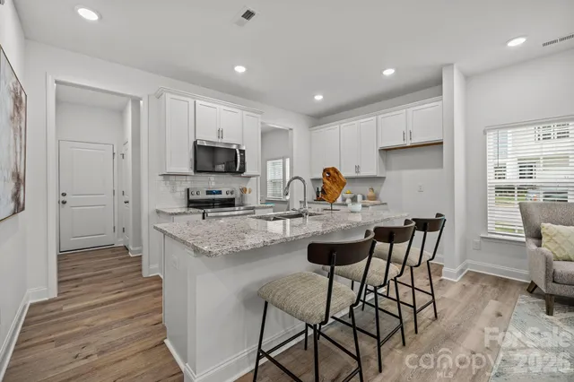 a kitchen with granite countertop a stove a sink and a refrigerator