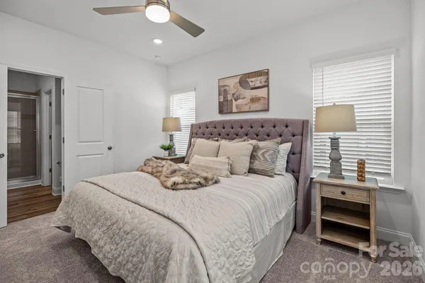 a bedroom with a bed and a lamp on dresser