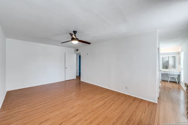 a view of an empty room with wooden floor