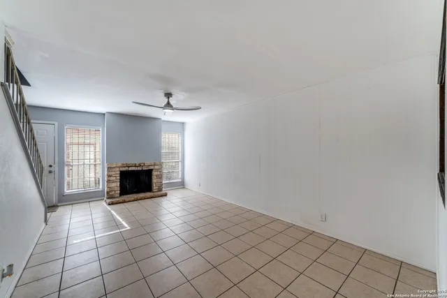 a view of empty room with wooden floor and fireplace