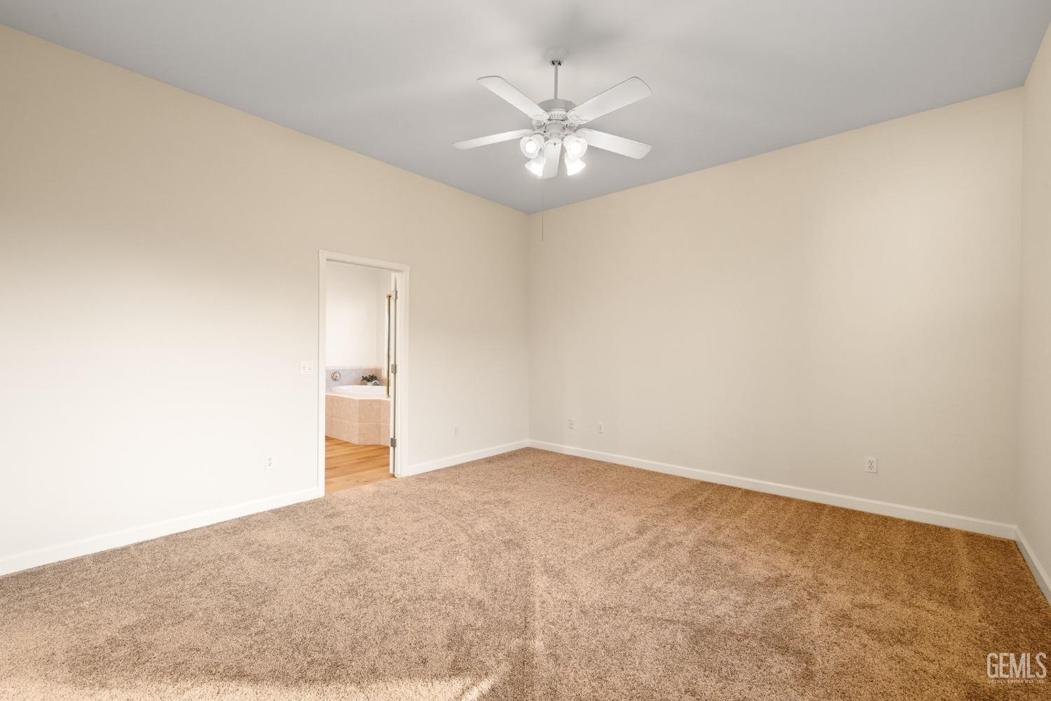 Undisclosed Address Bakersfield, CA 93313 - Photo 24 of 50 an empty room with a chandelier fan and windows