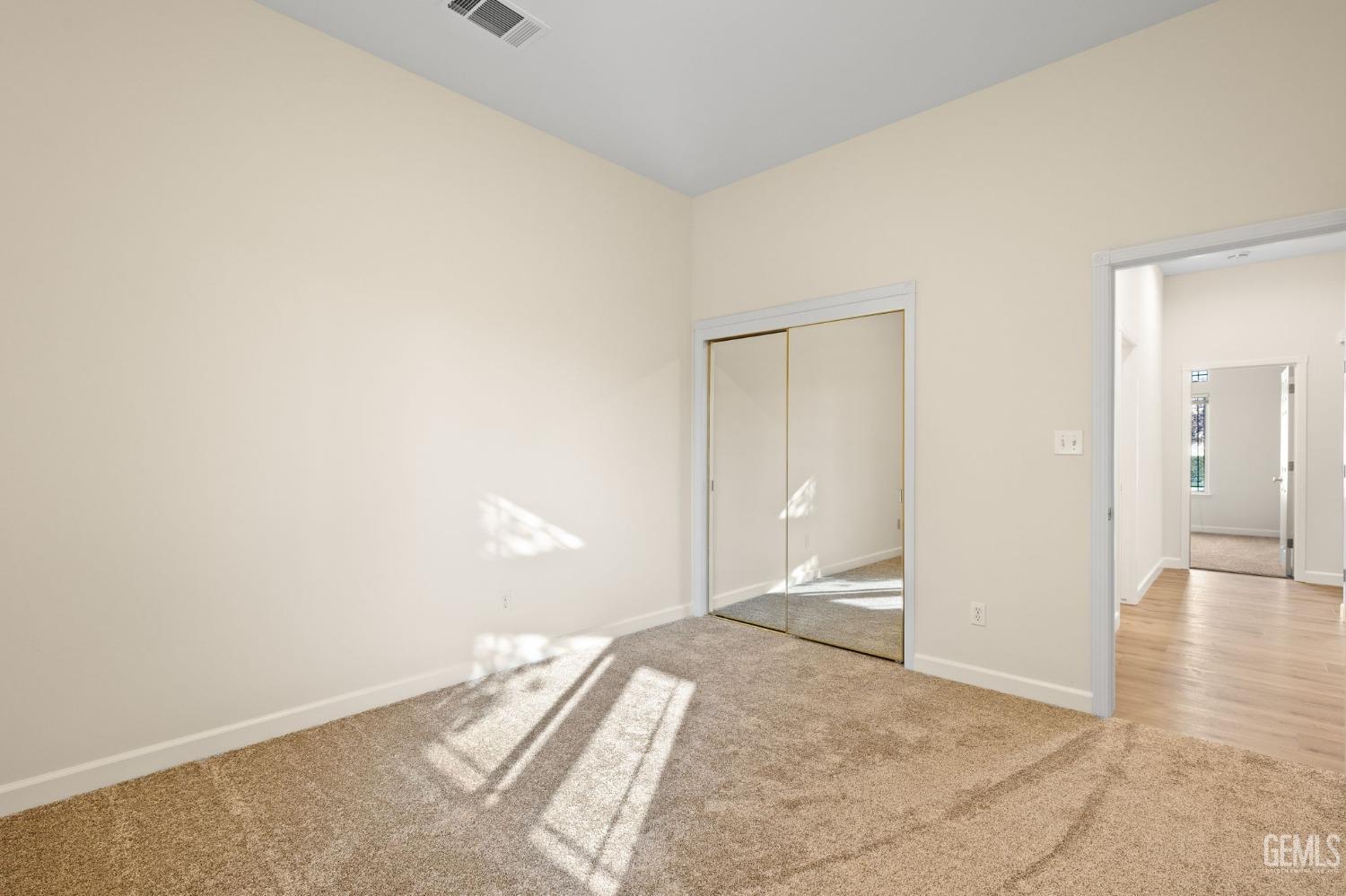 Undisclosed Address Bakersfield, CA 93313 - Photo 41 of 50 an empty room with wooden floor and bathroom view