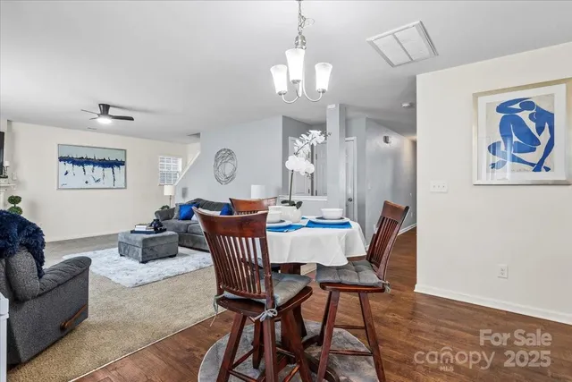 a view of a dining room with furniture a chandelier and wooden floor