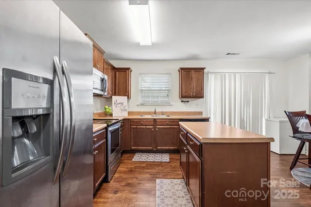 a kitchen with granite countertop a refrigerator stove and sink