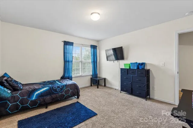 a bedroom with furniture and a flat screen tv