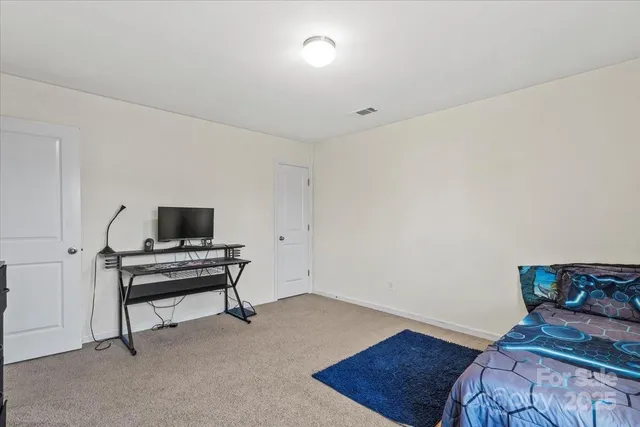 a bedroom with a bed and a computer on a table