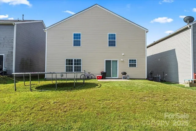 a view of pool with two windows and a yard
