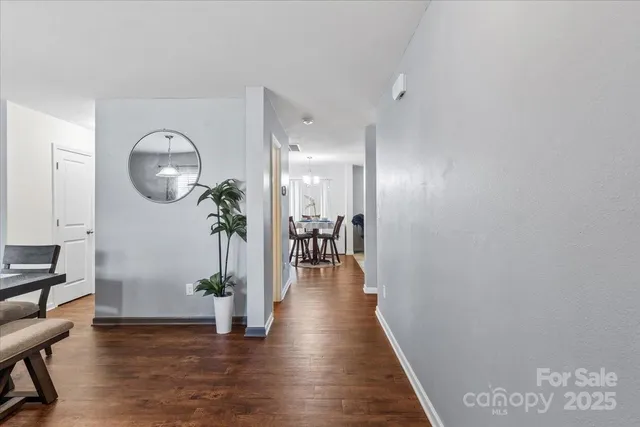 a view of a hallway to room with wooden floor