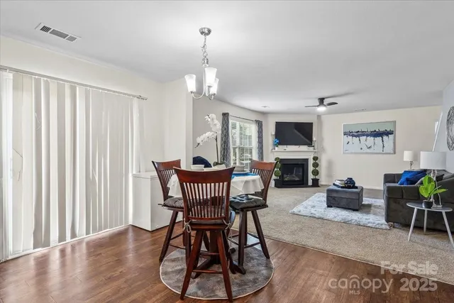 a view of a livingroom with furniture a fireplace and wooden floor