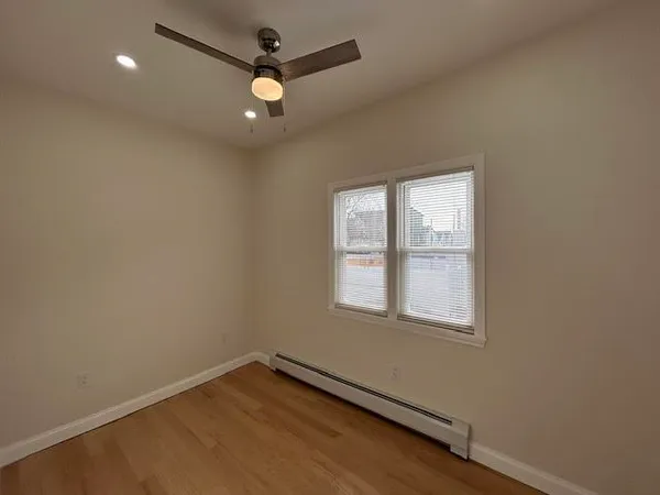 an empty room with a window and a fan