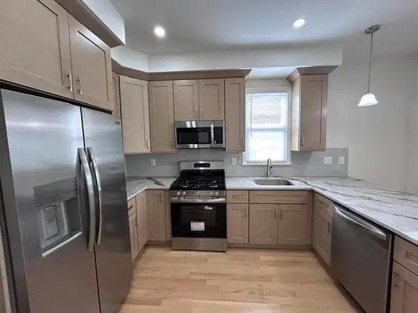 a kitchen with stainless steel appliances granite countertop a stove a sink and a refrigerator