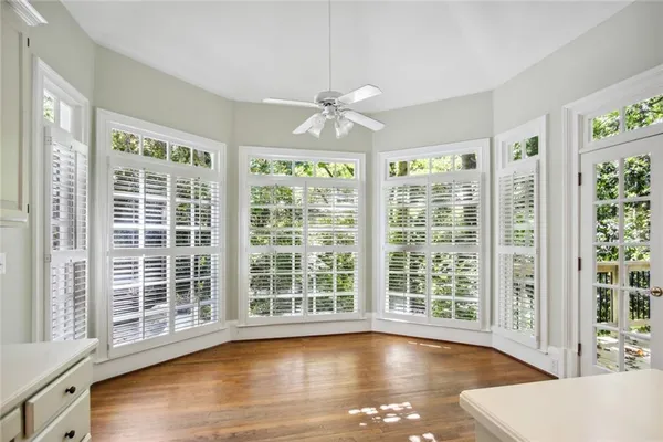 a view of empty room with wooden floor and fan