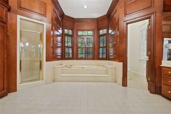 a spacious en suite bathroom with a tub and shower