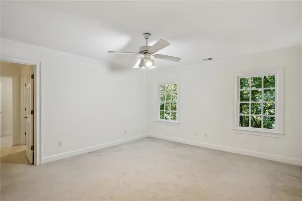 an empty room with a window and a fan