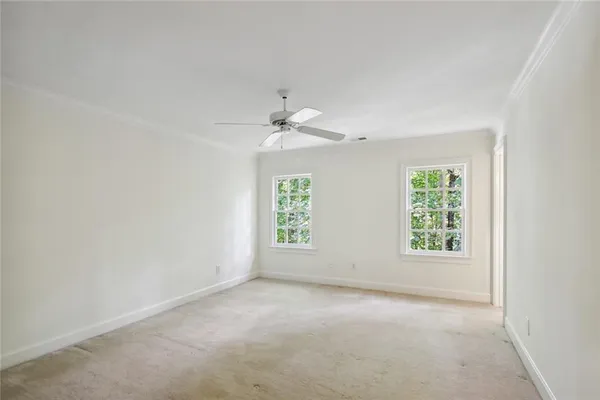 an empty room with a window and a ceiling fan