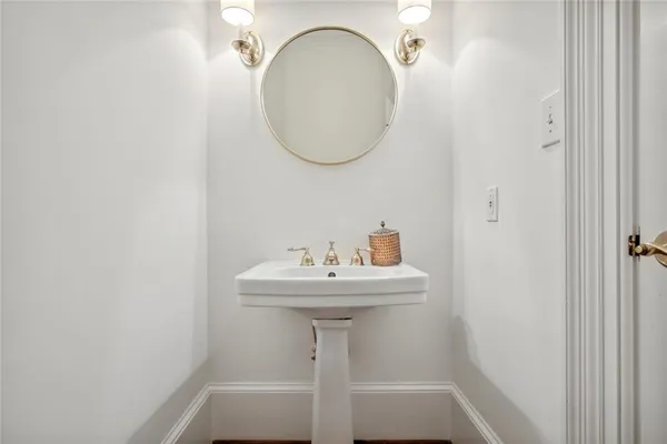 a bathroom with a sink a mirror and a lamp