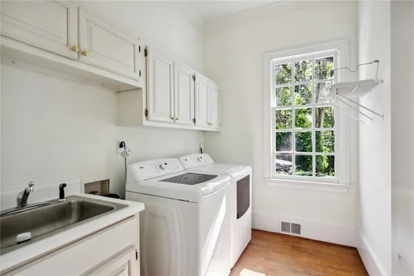 a utility room with sink dryer and washer