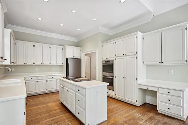 a kitchen with white cabinets and stainless steel appliances