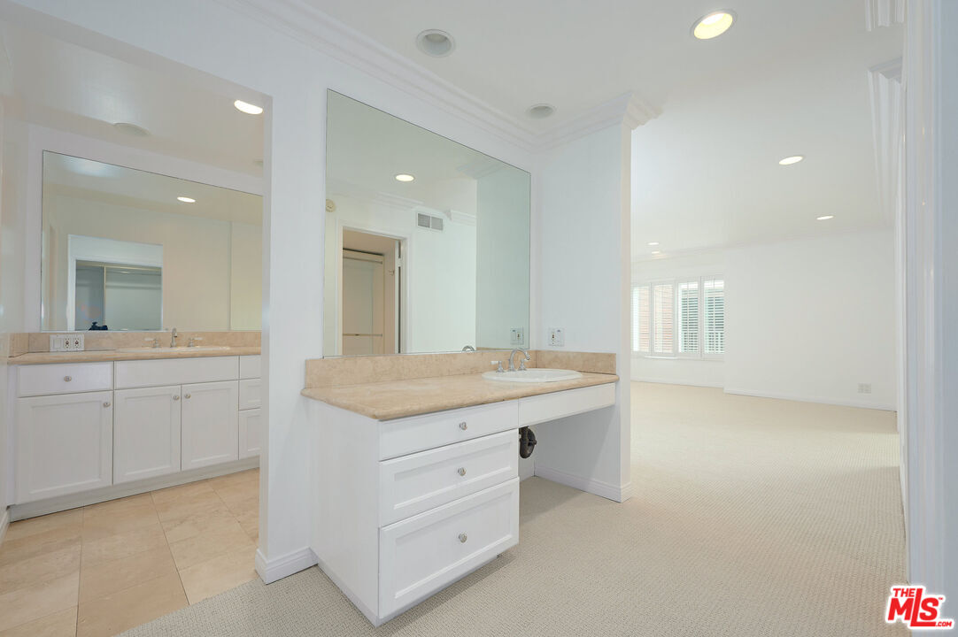 4250 Vía Dolce, Unit 321 Marina del Rey, CA 90292 - Photo 25 of 42 a bathroom with a granite countertop sink a mirror and a bathtub