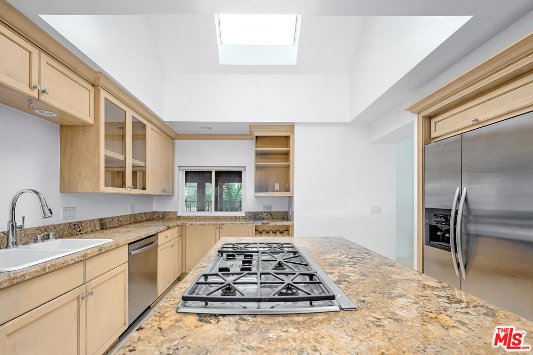 4250 Vía Dolce, Unit 321 Marina del Rey, CA 90292 - Photo 8 of 42 a kitchen with stainless steel appliances granite countertop a stove top oven a sink and dishwasher