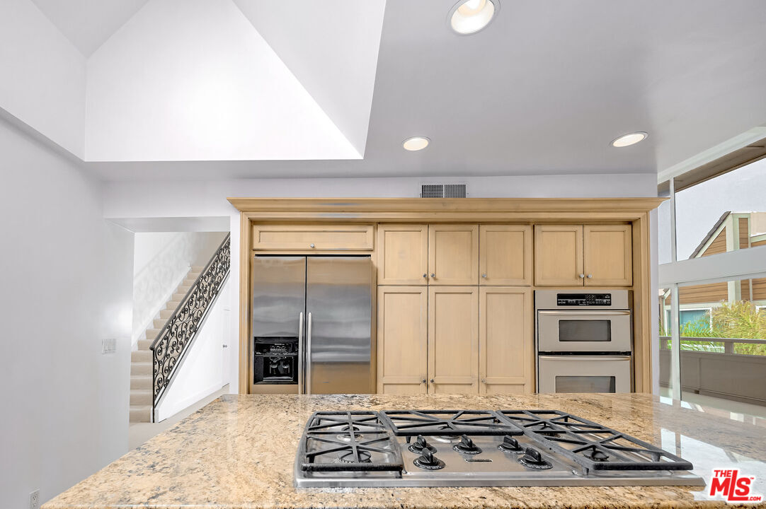 4250 Vía Dolce, Unit 321 Marina del Rey, CA 90292 - Photo 9 of 42 a kitchen with kitchen island granite countertop a stove and a refrigerator