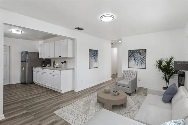 a living room with furniture and kitchen view