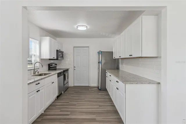 a kitchen with stainless steel appliances a sink stove and cabinets