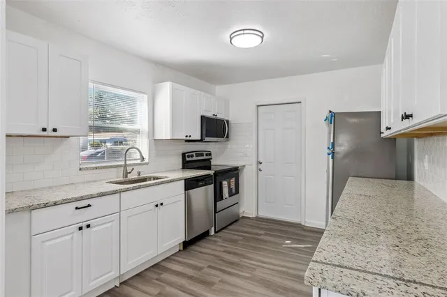 a kitchen with appliances a sink and cabinets