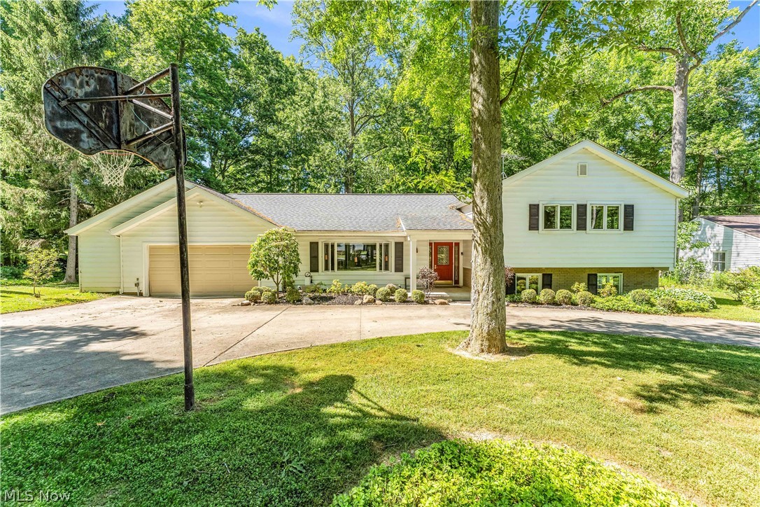 6821 Thornapple Road Gates Mills, OH 44040 - Photo 2 of 42 Sprawling ranch-style home featuring white siding, a contrasting red front door, and a detached two-car garage