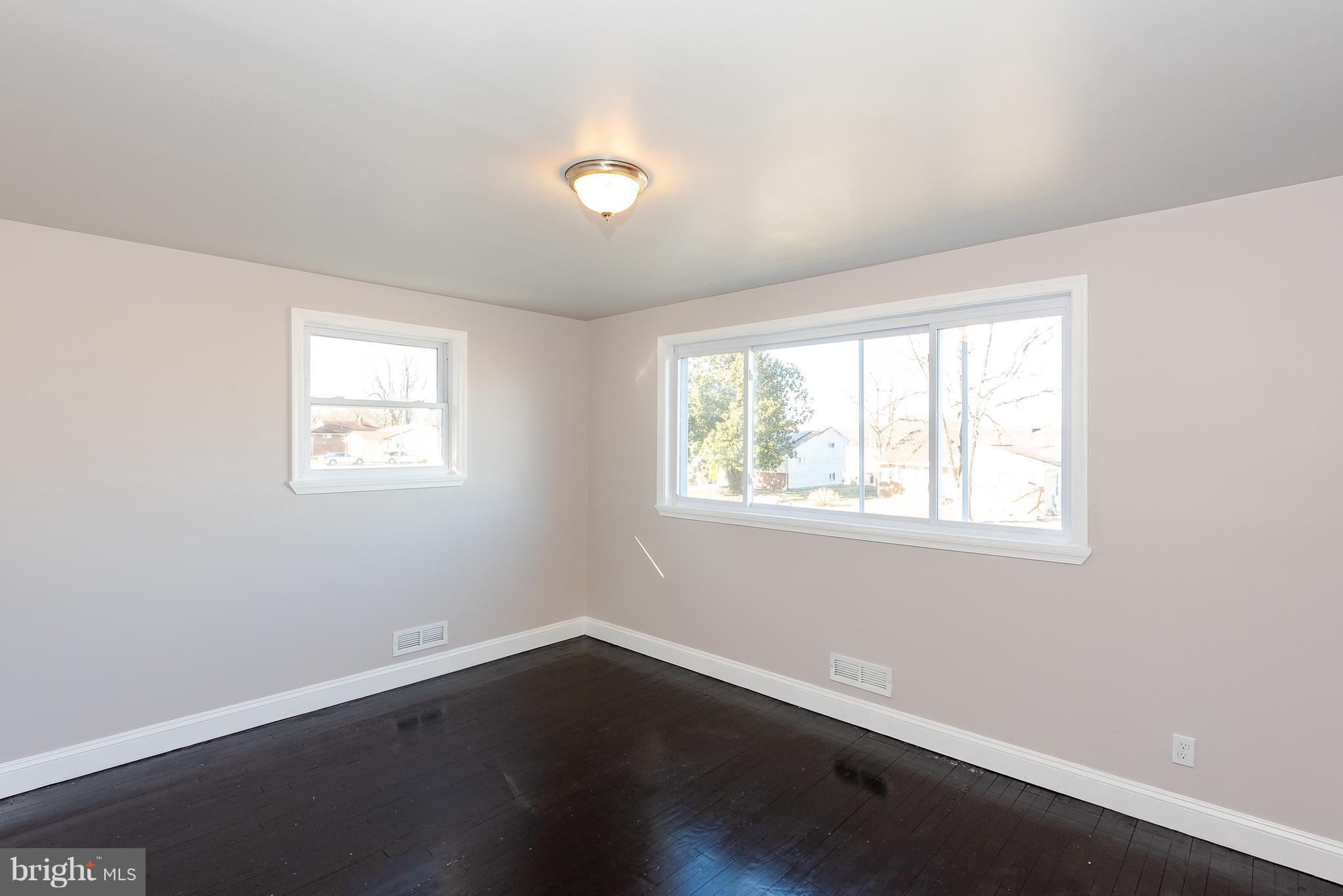 3327 Essex Road Baltimore, MD 21207 - Photo 13 of 35 an empty room with wooden floor and windows