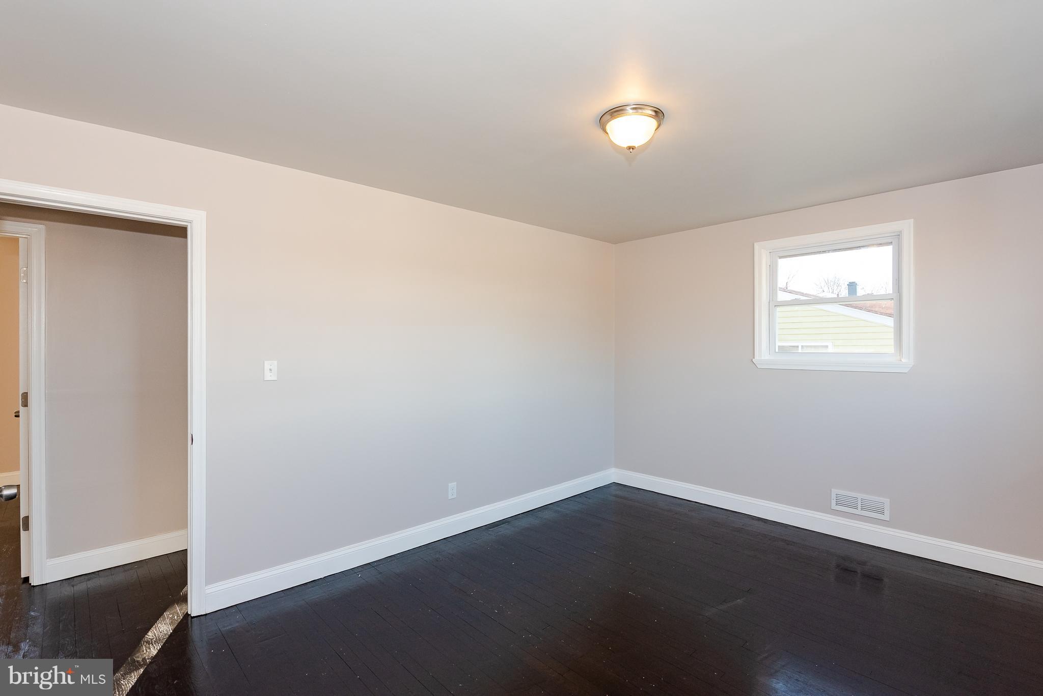 3327 Essex Road Baltimore, MD 21207 - Photo 14 of 35 an empty room with wooden floor and windows