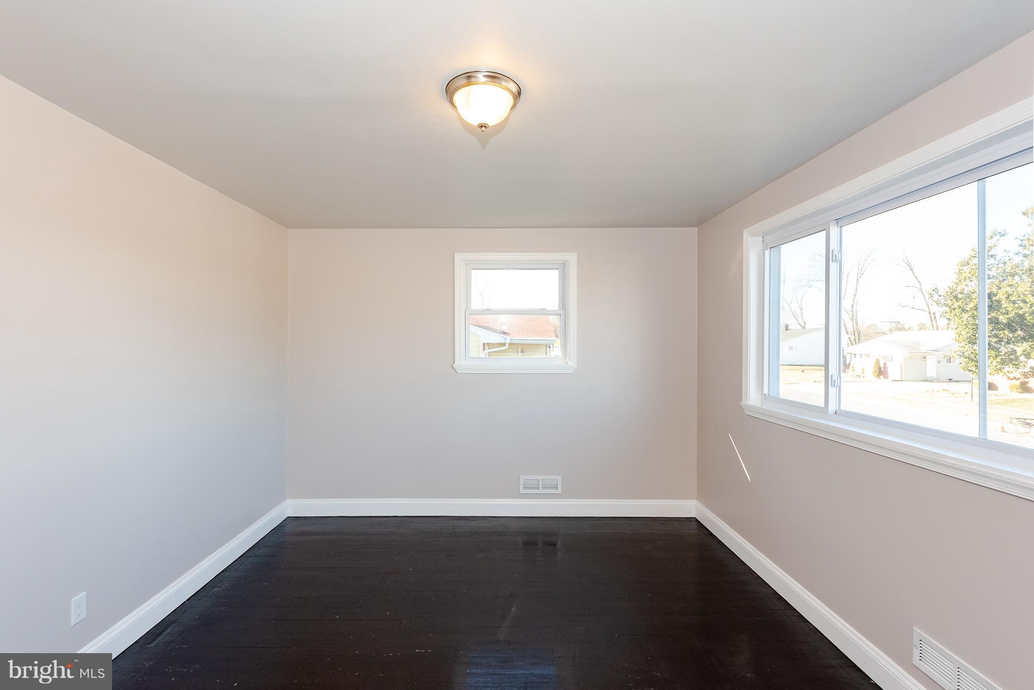 3327 Essex Road Baltimore, MD 21207 - Photo 16 of 35 an empty room with wooden floor and windows