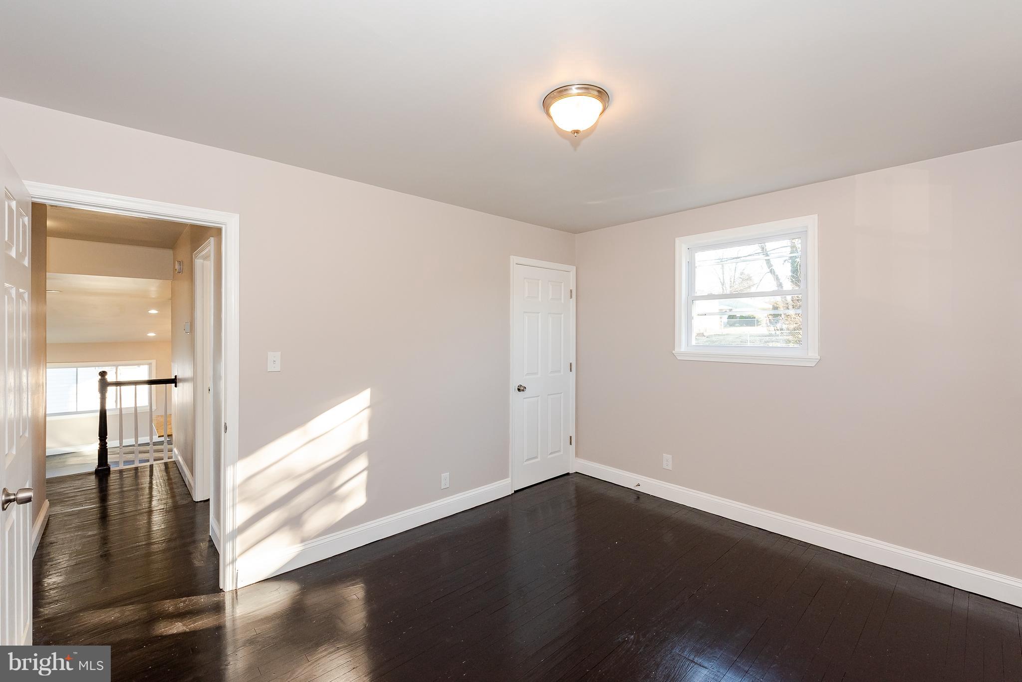 3327 Essex Road Baltimore, MD 21207 - Photo 21 of 35 an empty room with wooden floor and windows