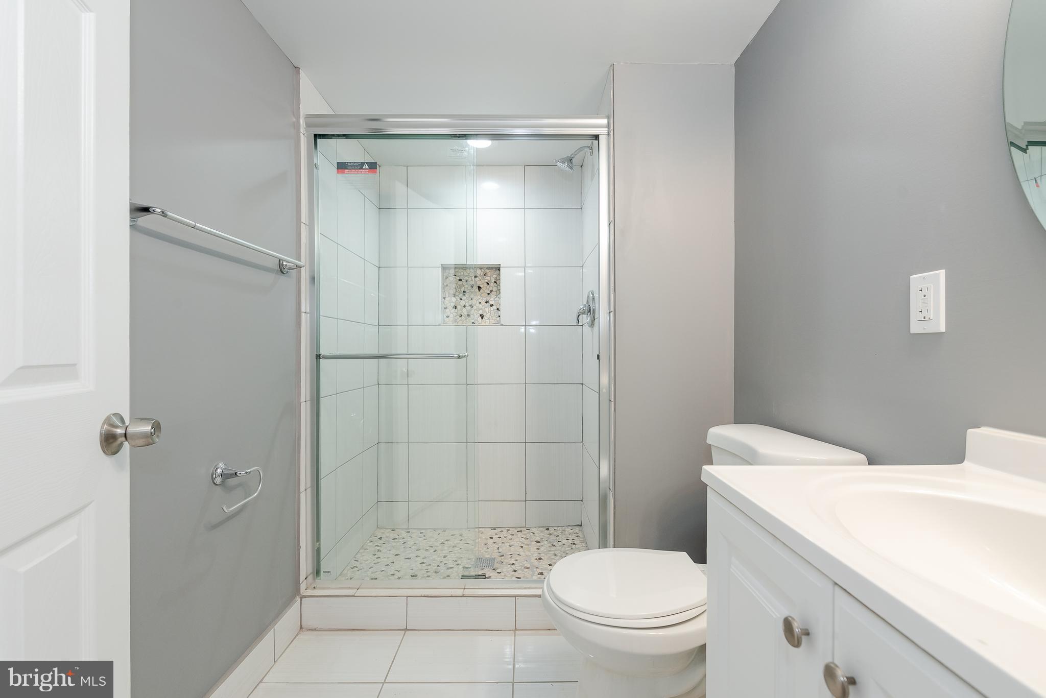 3327 Essex Road Baltimore, MD 21207 - Photo 29 of 35 a bathroom with a shower a toilet and a sink
