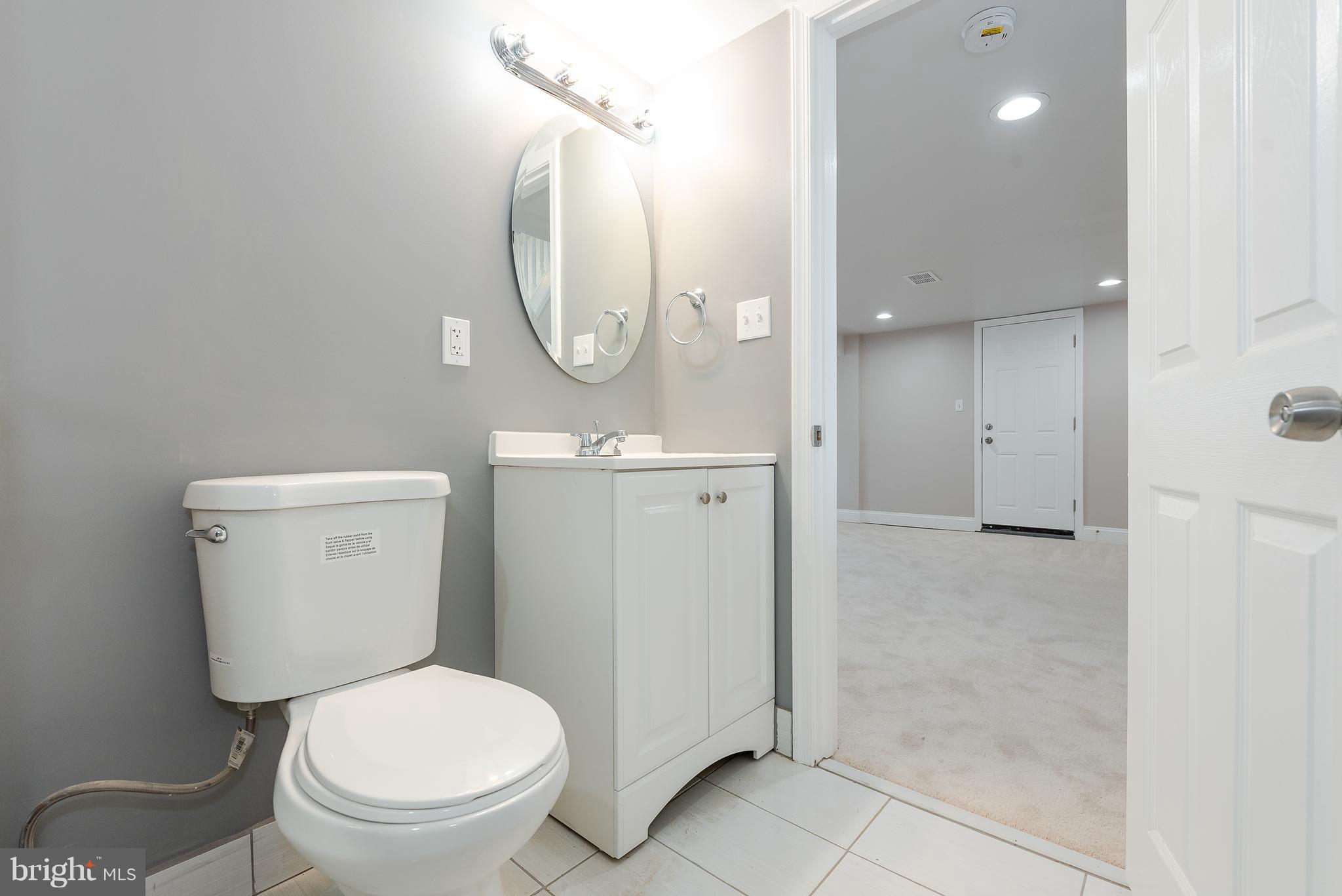 3327 Essex Road Baltimore, MD 21207 - Photo 31 of 35 a bathroom with a toilet a sink and a mirror