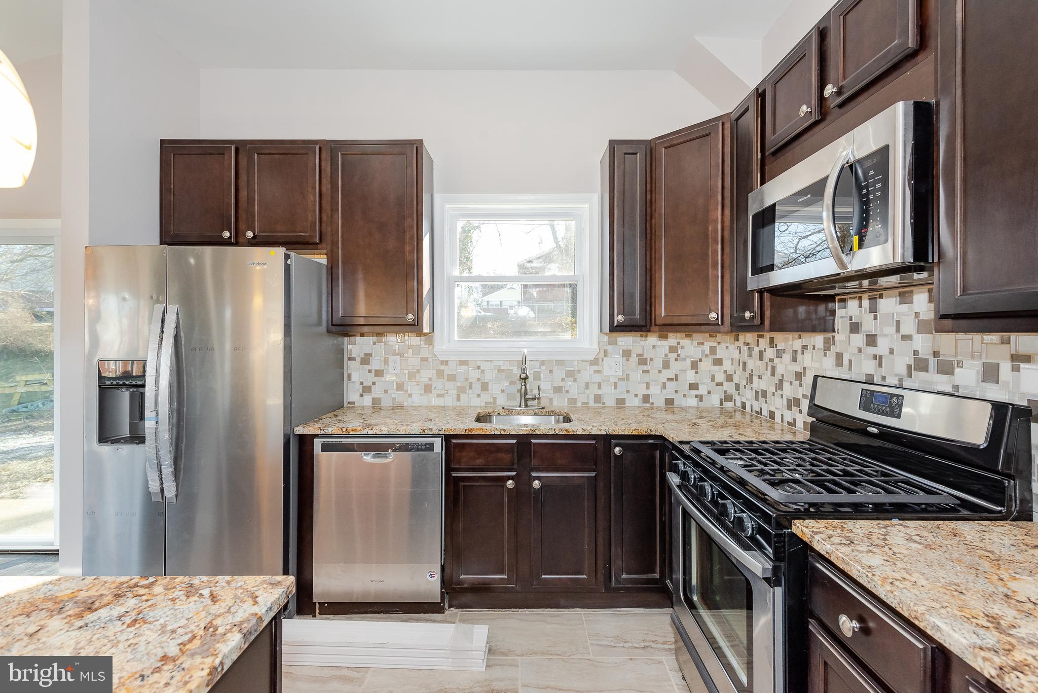 3327 Essex Road Baltimore, MD 21207 - Photo 8 of 35 a kitchen with stainless steel appliances granite countertop a stove sink microwave and refrigerator